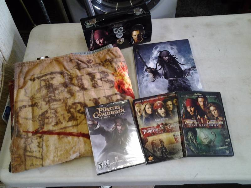 lot 74 image: Pirates Of The Caribbean DVDs & Beach Towel