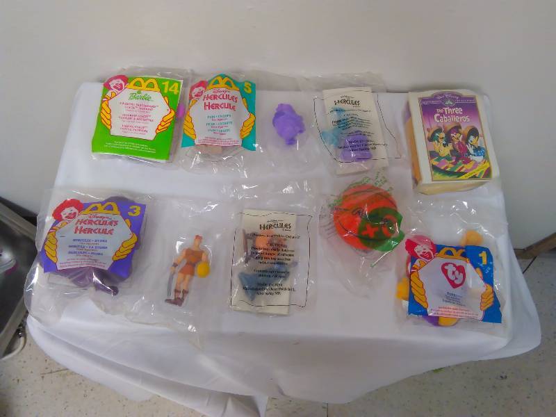 lot 47 image: Lot of 10  Happy meal toys, new in sealed bag, Barbie, Ty, Hercules, and more
