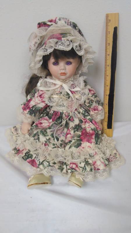lot 106 image: Vintage Porcelain Doll Brunette Floral Dress Bonnet, violet eyes.