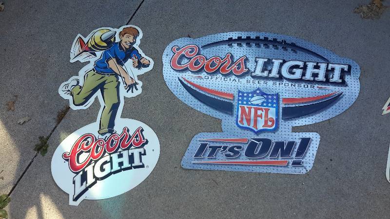 Aluminum Coors bar signs. The 1st depicts a dart thrower. The 2nd is a logo of the NFL official sponsor.