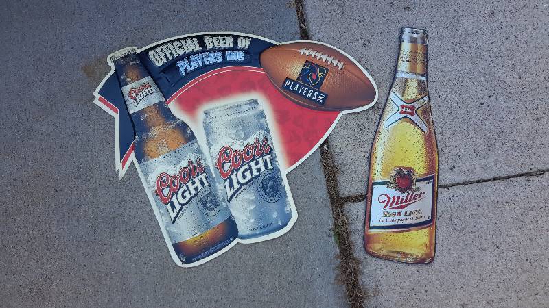Aluminum Coors official beer of players incorporated and Miller High life bottle signs.