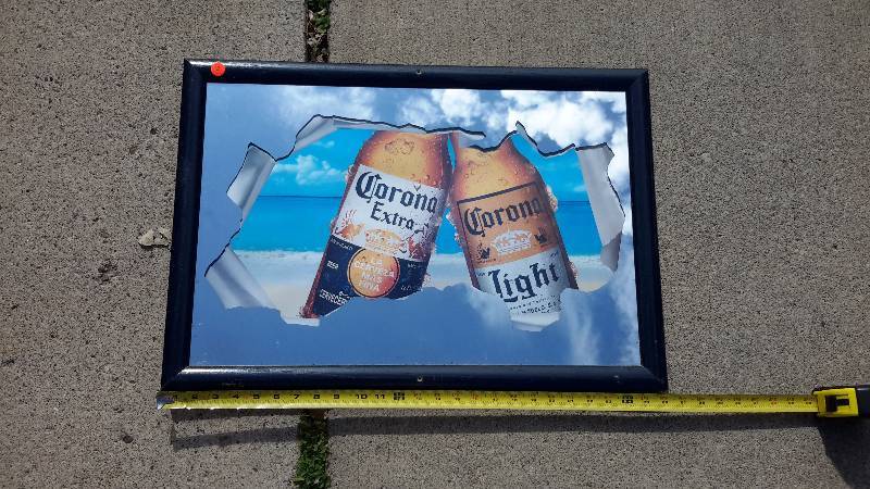 A framed Corona broken mirror sign. From 2003.