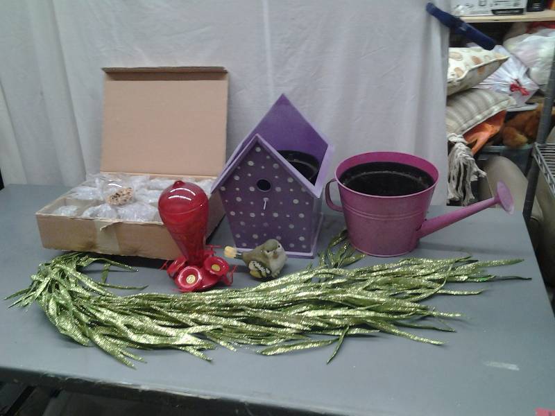 lot 14 image: Metal Watering Can, Bird House Planter, Hummingbird Feeder, Glitter Greenery, 10-Footed Glass Bulbs With Pebbles