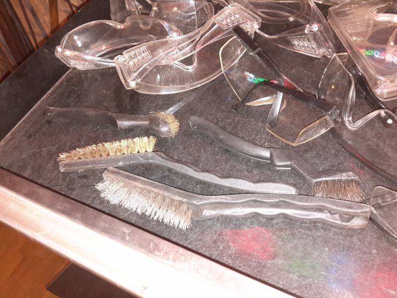 lot 86 image: Lot of plastic protective goggles and small wire brushes as pictured.