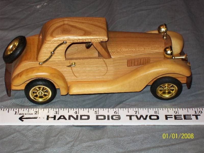 lot 30 image: Exquisite Multi Wood Touring Model Car with Rubber Wheels. 10 long