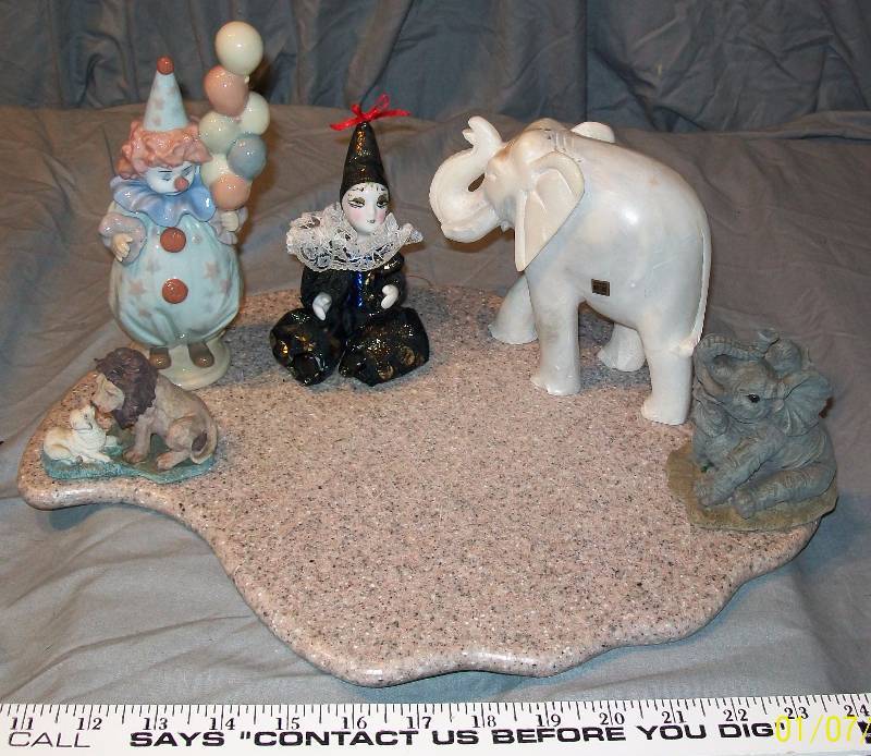lot 40 image: 6 Piece FigurineStatueNick Nack Ensemble of Elephants, LLARDO & Pierrot Clowns, Lion-Lamb. & Stone PlatformCutting Bd
