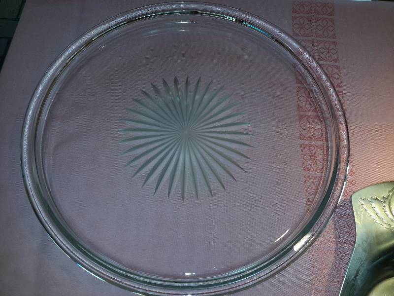 lot 31 image: 1 Cut glass Cake plate, heavy glass serving platter with star cut center. Both 11 12 in diam.    Kensing Ware Serving platter.