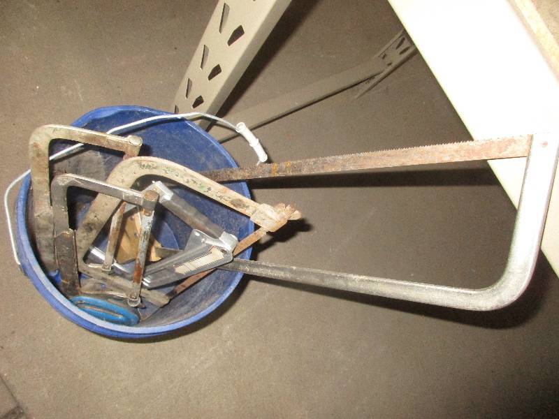 lot 18 image: bucket of hand saws and 1 level
