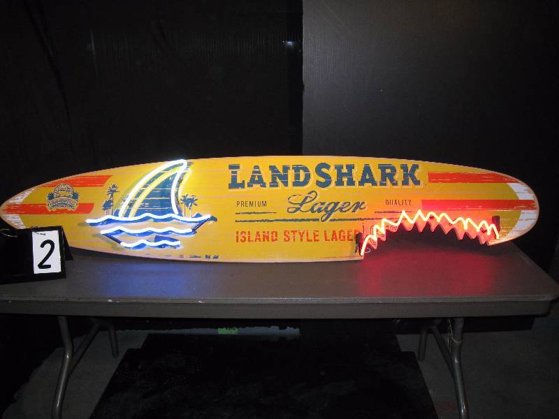 lot 2 image: Landshark surf board - board alone is hard to find, this one is even better. Customized with Ruby Red bite mark and Great White shark fin. Stay out of the water