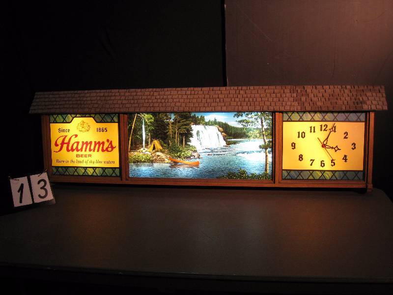 lot 13 image: Hamms clock with canoe scene. Large Hamms Beer lighted sign with Hamms logo on left, scenic camping picture with waterfall in center, and clock with sweep secondhand on right. All lights work like they should.