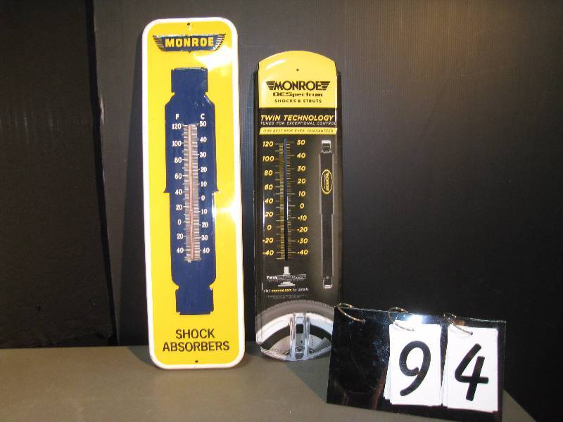 lot 94 image: Monroe Shock - 2 signs in this lot, 1 older thermometer with thermometer 26 h x 7 w, 1 newer without thermometer 24 h x 7 w