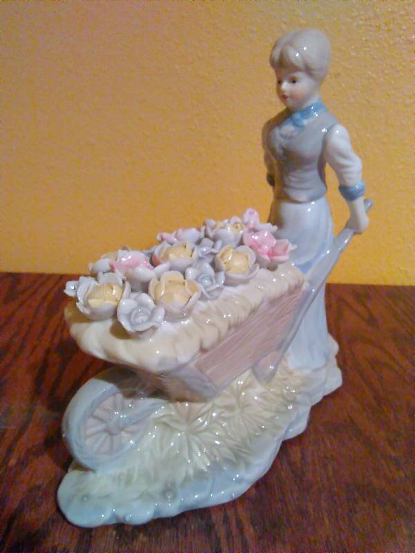 lot 217 image: Porcelain peasant girl pushing flower cart