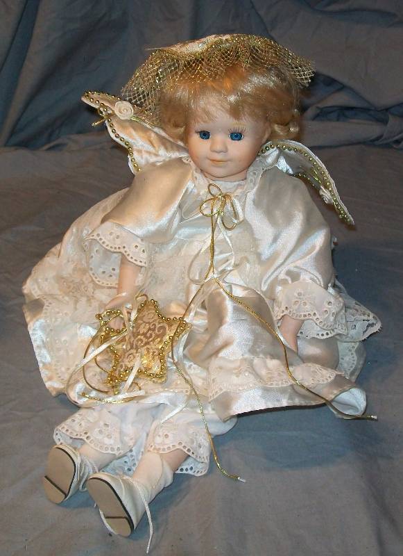 lot 87 image: 12 Sitting Christmas Collector Young Girl Doll Angel Blond Hair done up with Braids, Finely Detailed Face & Clothing.