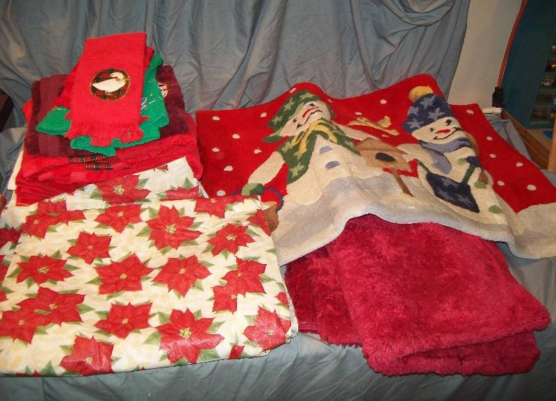 lot 125 image: Assorted HandGuestHoliday Towels 3- Small Area FloorDoor Bathroom Rugs  Plastic Poinsettia Table Cloth. See Pic
