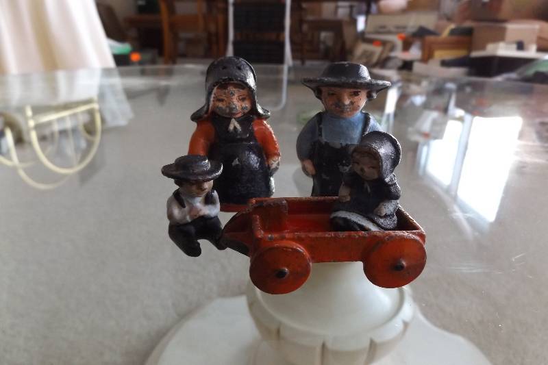lot 458 image: Cast metal man and woman salt and pepper, metal boy and girl, metal red wagon