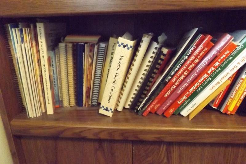 lot 460 image: Shelf of recipe books, Wild Rice, churches, ND Centennial, more