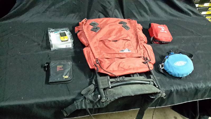 lot 46 image: Hikers backpack, 1st aid kit, water canteen, Garmin GPS, and sunscreen kit
