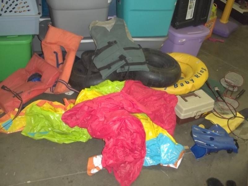 lot 81 image: Outdoor water toys, intertubes, tackle box, badminton bats, life vests, flippers, green cushion
