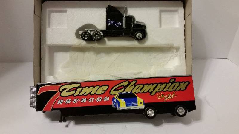 lot 144 image: Action Racing Collectables 164th Scale 7 Time Champions Richard Petty and Dale Earnhardt Race Car Transporter.