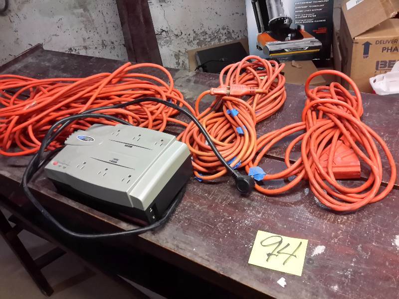 lot 94 image: Lot of 3 electric cords and surge protector.. Looks like 100, 50, 25 ft cords.. Protector untested