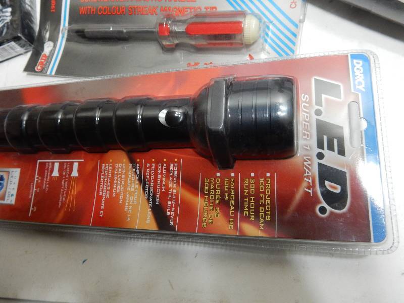lot 77 image: LED flashlight box of box cutters (approx 30) Tie Downs Large container of 3 ft tape measures  Long Neck Needle nose pliers 2 combination screw driver sets