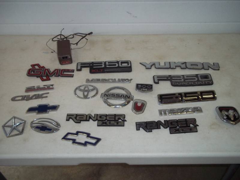 lot 35 image: Assorted automotive emblems, vintage electric inverter