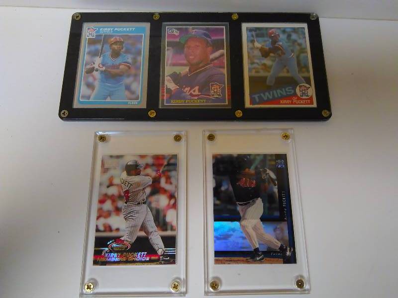 lot 652 image: Kirby Puckett Baseball Cards, set of 5 Cards, in Secured Cases, set of 3 together measures 9.5 x 4.5 85 Fleer  85 Dunruss  85 Topps, the other 2 measure 3 18 x 5  in. (93 Topps and 94 Upper Deck)