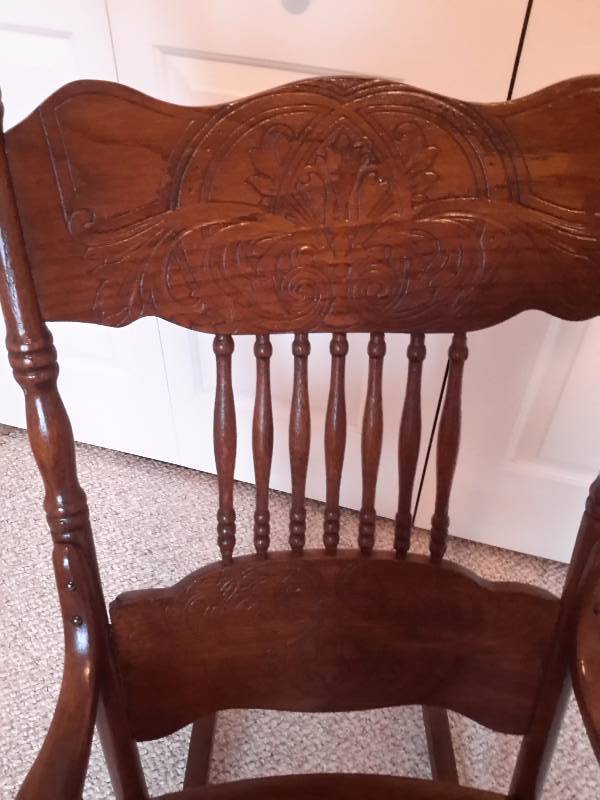 Nice old rocker with leather seat and carved design background. Spindle back