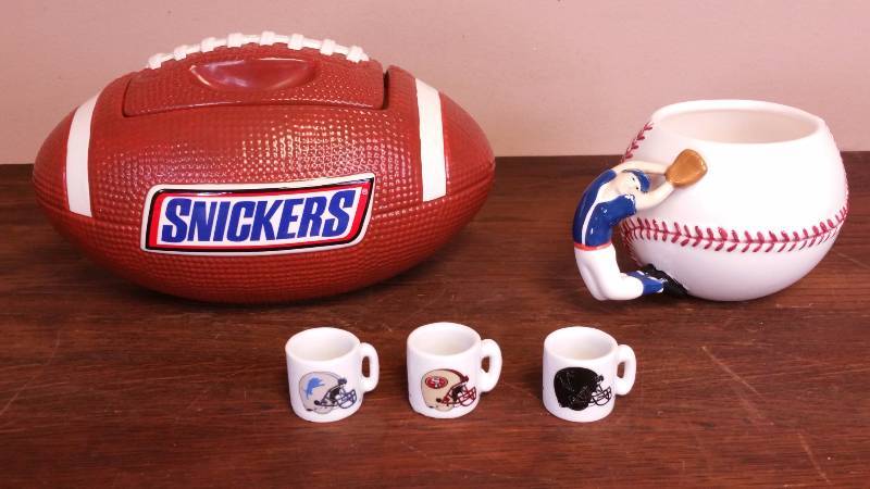 lot 68 image: Snickers Ceramic Jar, Baseball Coffeemate Mug, and NFL Mugs