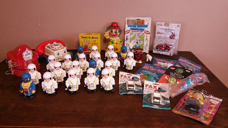 lot 76 image: Large Group of Wind Up Astronauts, Fire Chief Hats, Clown Coin Bank, Dennis the Mennis Napkins, and More