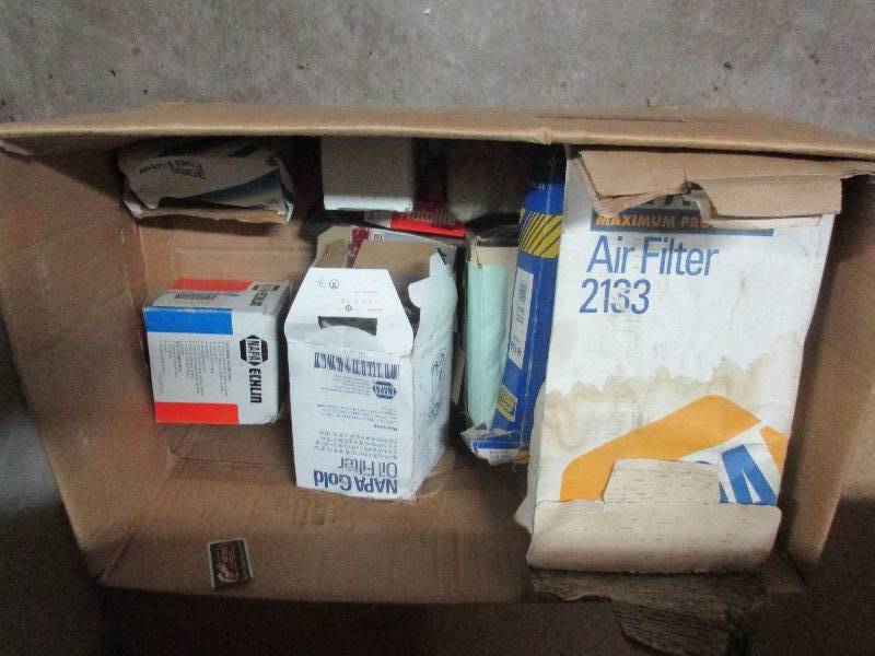box of car air and oil filters and tools