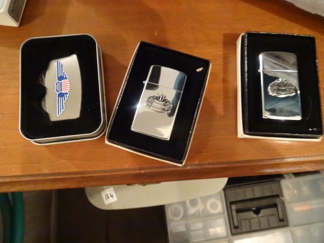 lot 204 image: Zippo lighters. 2 are the same. One...