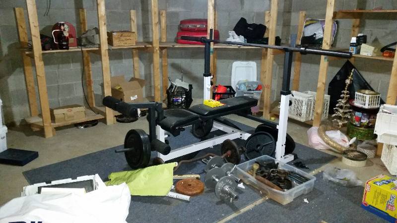 lot 130 image: Room Lot Includes Weight Bench with Bar, Weights, Free Weights, Suitcases, Table, File Cabinets, Mantle Clock, Beer Bottle, And More