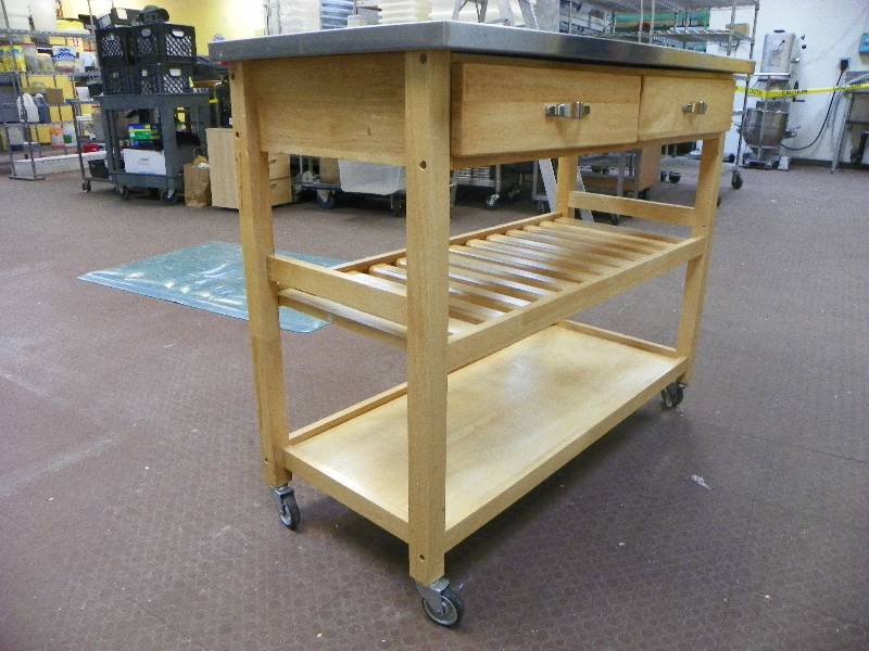 Island table on wheels, wood construction with stainless top, 2 drawers and 2 shelves. 44wide x 36 tall x 26 deep