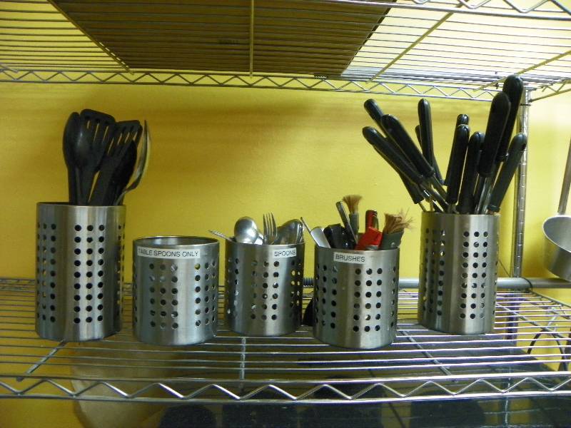 Kitchen utensils and round storage bins they are in.