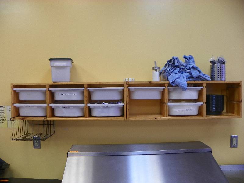 Wall hung shelving unit, includes tubs and other items.