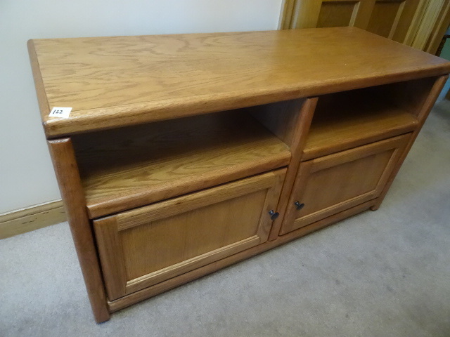 lot 122 image: Wood TV stand on wheels. 2 doors. 4...