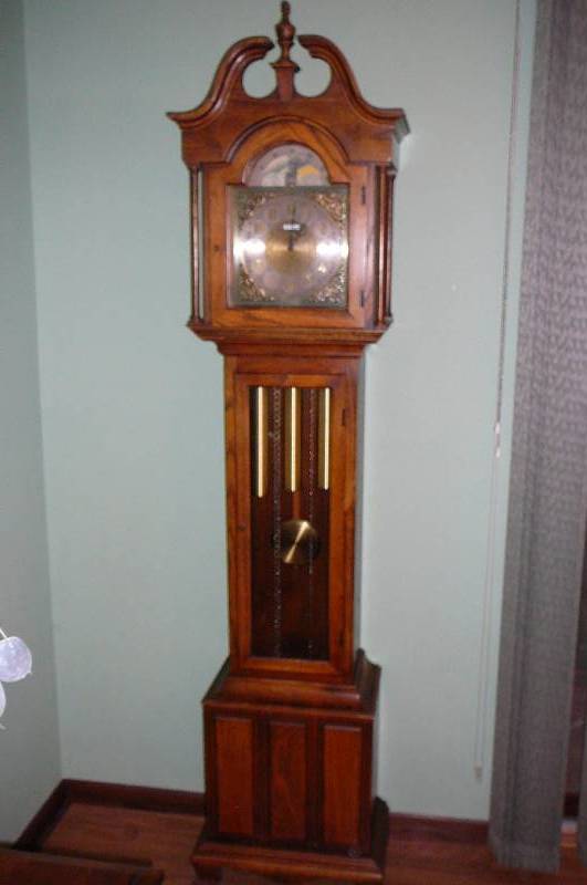 lot 18 image: Oak Grand father clock Howard Miller with Book, Model 61124 #155 Triple Chain Weight Driven Unit
