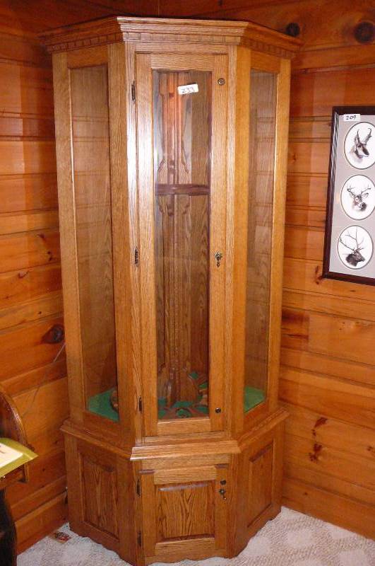lot 233 image: Oak Gun Display, Custom Built Corner Display with light and lower cabinet, Holds 12 guns with lock angle Keys 77 t x 44
