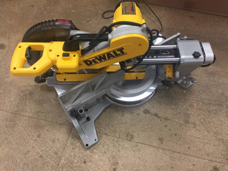 lot 130 image: DEWALT 15 Amp 12 in. Double Bevel Sliding Compound Miter Saw Model # DWS780 in like New conditions