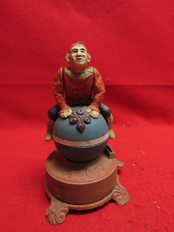 lot 226 image: Vintage Clown on Globe Cast Iron Mechanical Bank Funny Clown Americana,