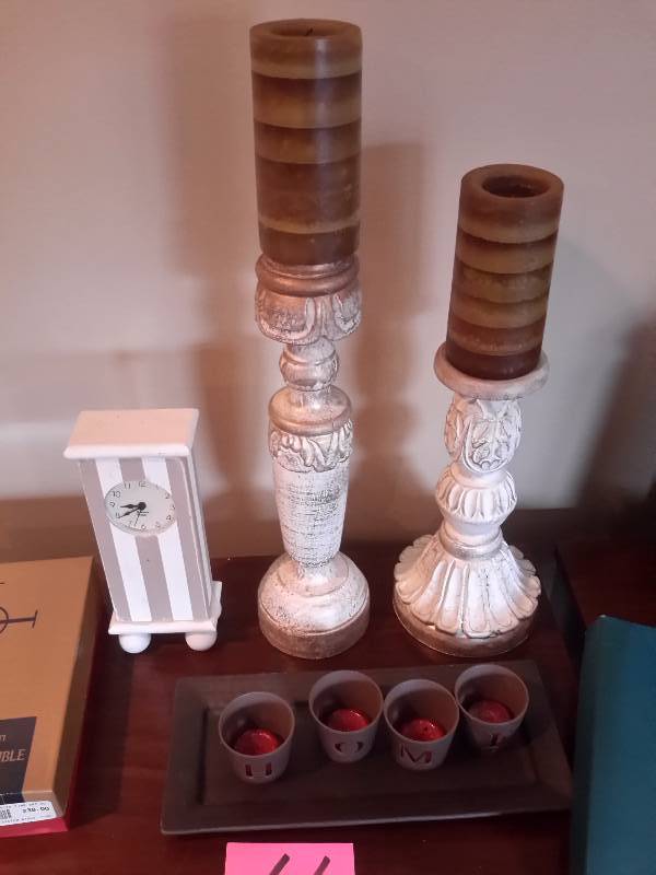 lot 66 image: Misc. Items as pictured Includes  Holy Bible, 2 WOOD Candle Sticks, Small electric clock, votive candles and holderstray Brown  lamp shade.. About 12in diameter.. Christmas platter