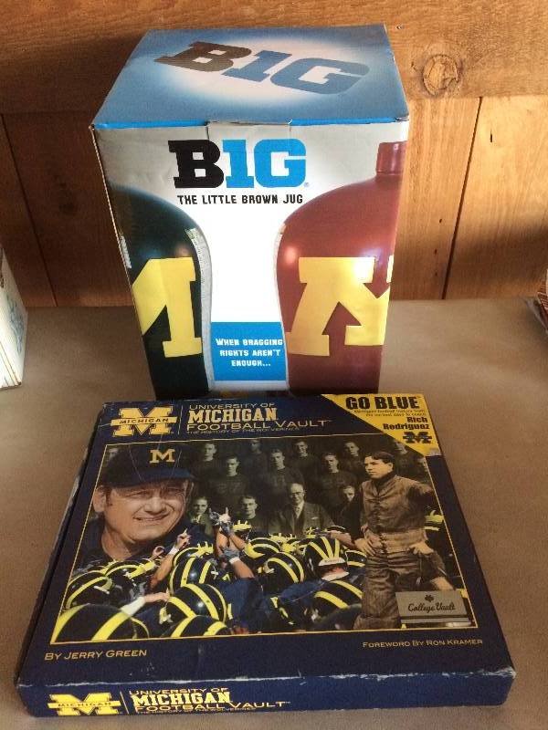 lot 3 image: Collectible Michigan State Memorabilia Jug - Believe to Be New In Box &  University of Michigan Football Vault  The History of the Wolverines by Jerry Green - Excellent Condition