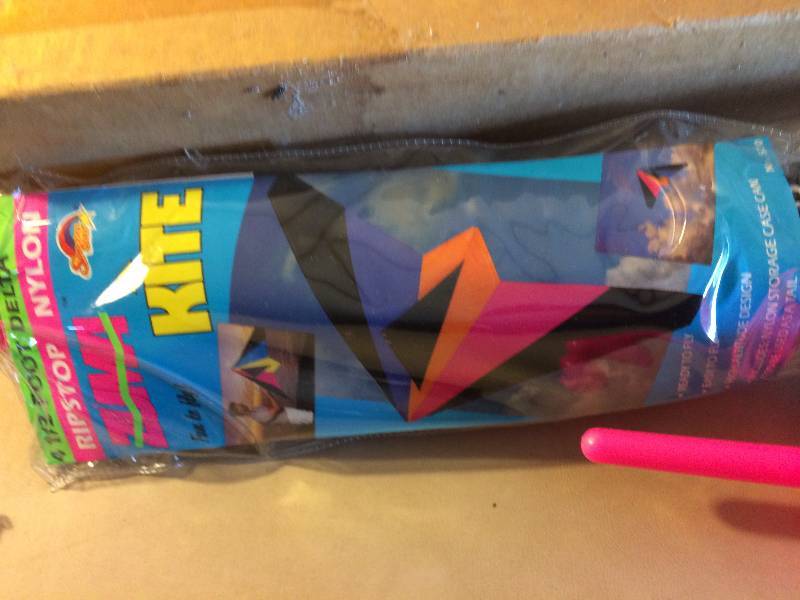 lot 12 image: New In Box Professional Into The Wind Delta 4 12 Foot Kite With  200 Feet of 50-lb. polyester line on a handle.