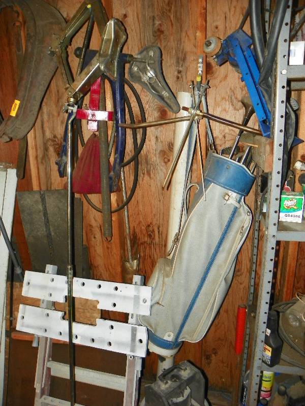 lot 115 image: Items on wall, golf clubs, bike parts, and other misc