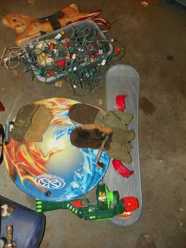 lot 123 image: Snow board, saucer, tote of misc and christmas lights, candy canes and toy horse