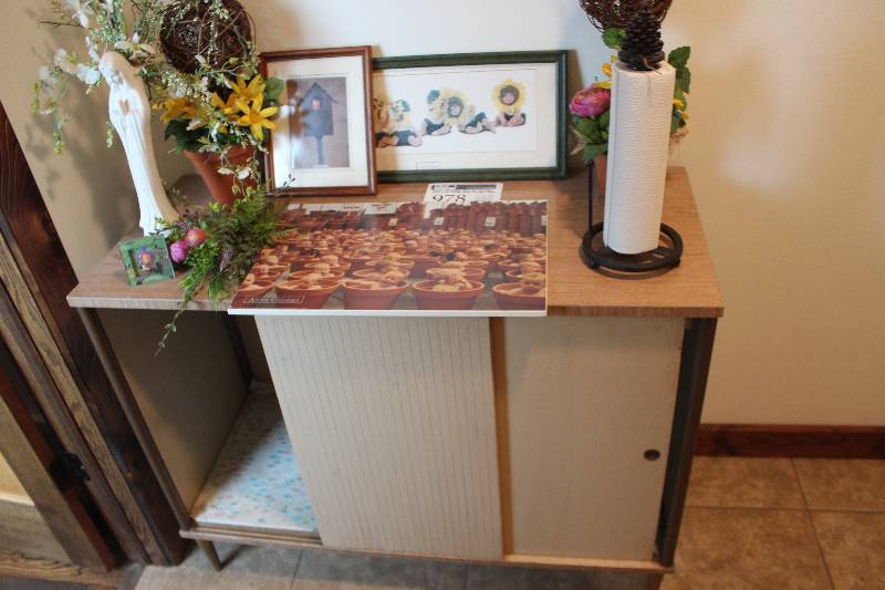 lot 978 image: Assorted Pictures, Praying Figure, Pine Cone Paper Towel Holder, Cabinet Included