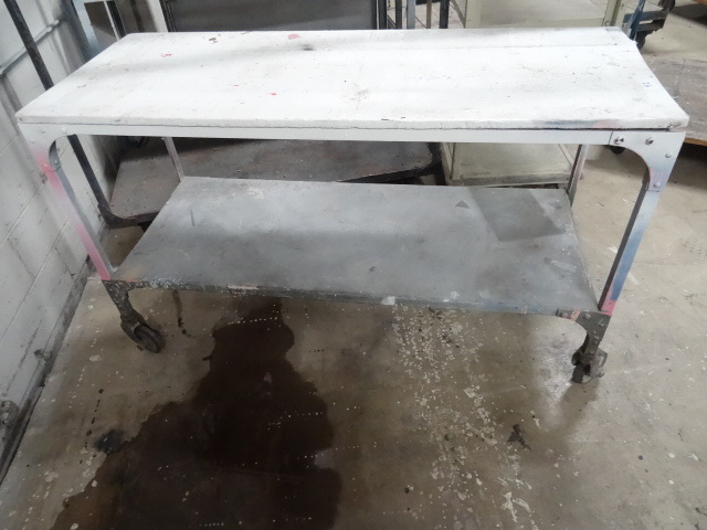 lot 92 image: 4 wheel metal framed table. 60 x 24...