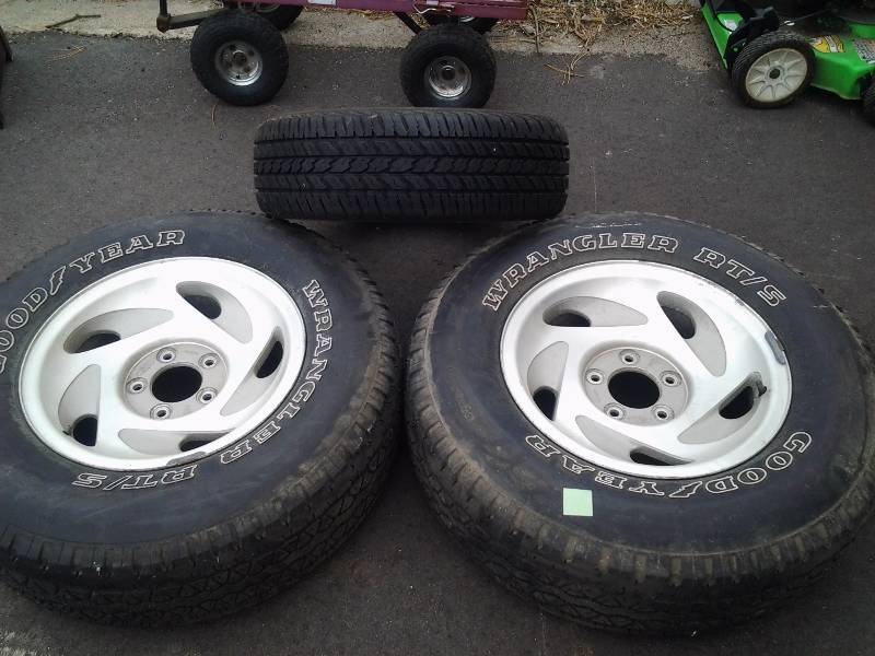 lot 28 image: 2-Goodyear Wrangler Tires 2657017 On Ford 5 Lug Aluminum Wheels With Trim Center Caps & 1-Douglas 2056516 Tire