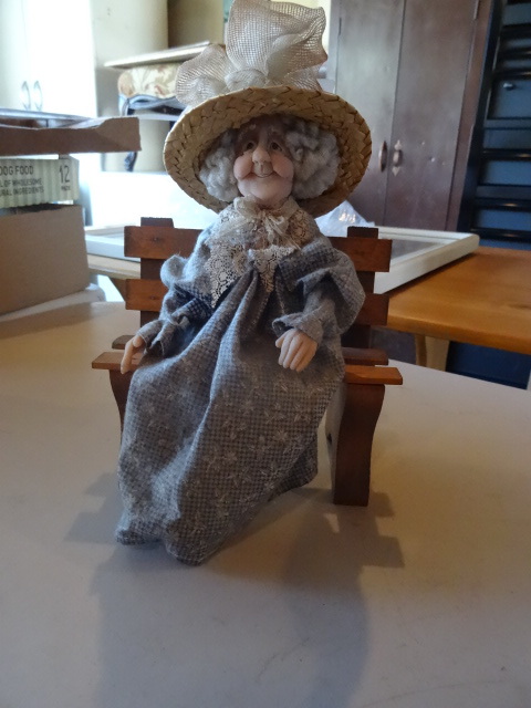 lot 30 image: Grandma doll on wood bench...